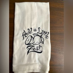 Kitchen towel with embroidery saying Add A Little Zest